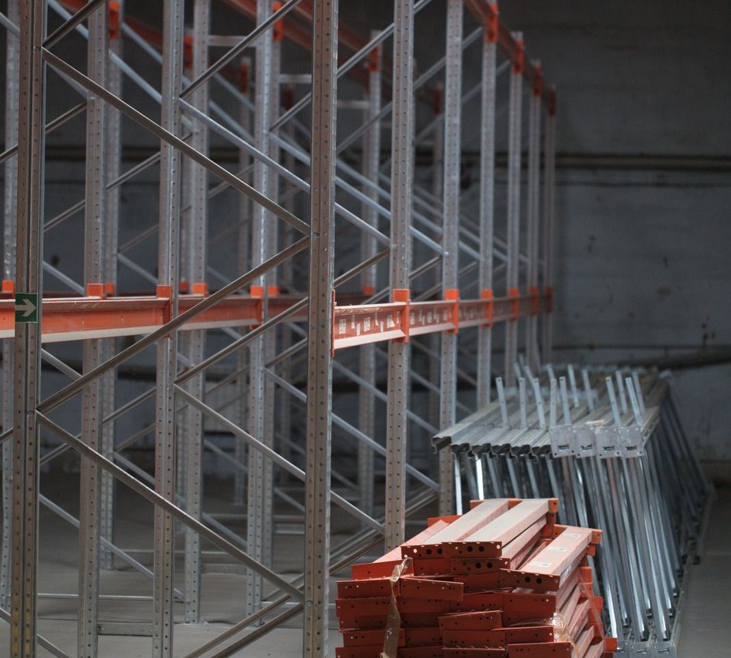 A warehouse with a lot of shelves and a stack of wood