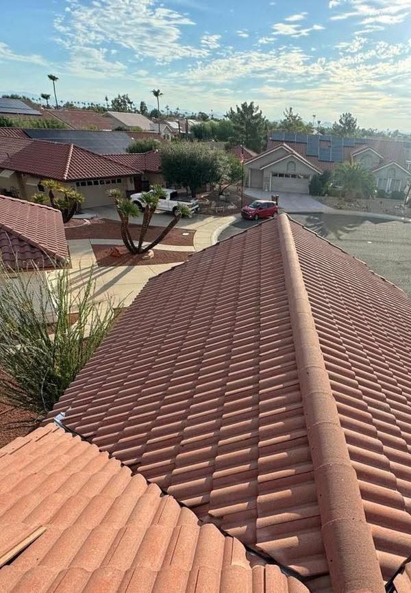 Red-tiled rooftops in a suburban neighborhood under a bright sky