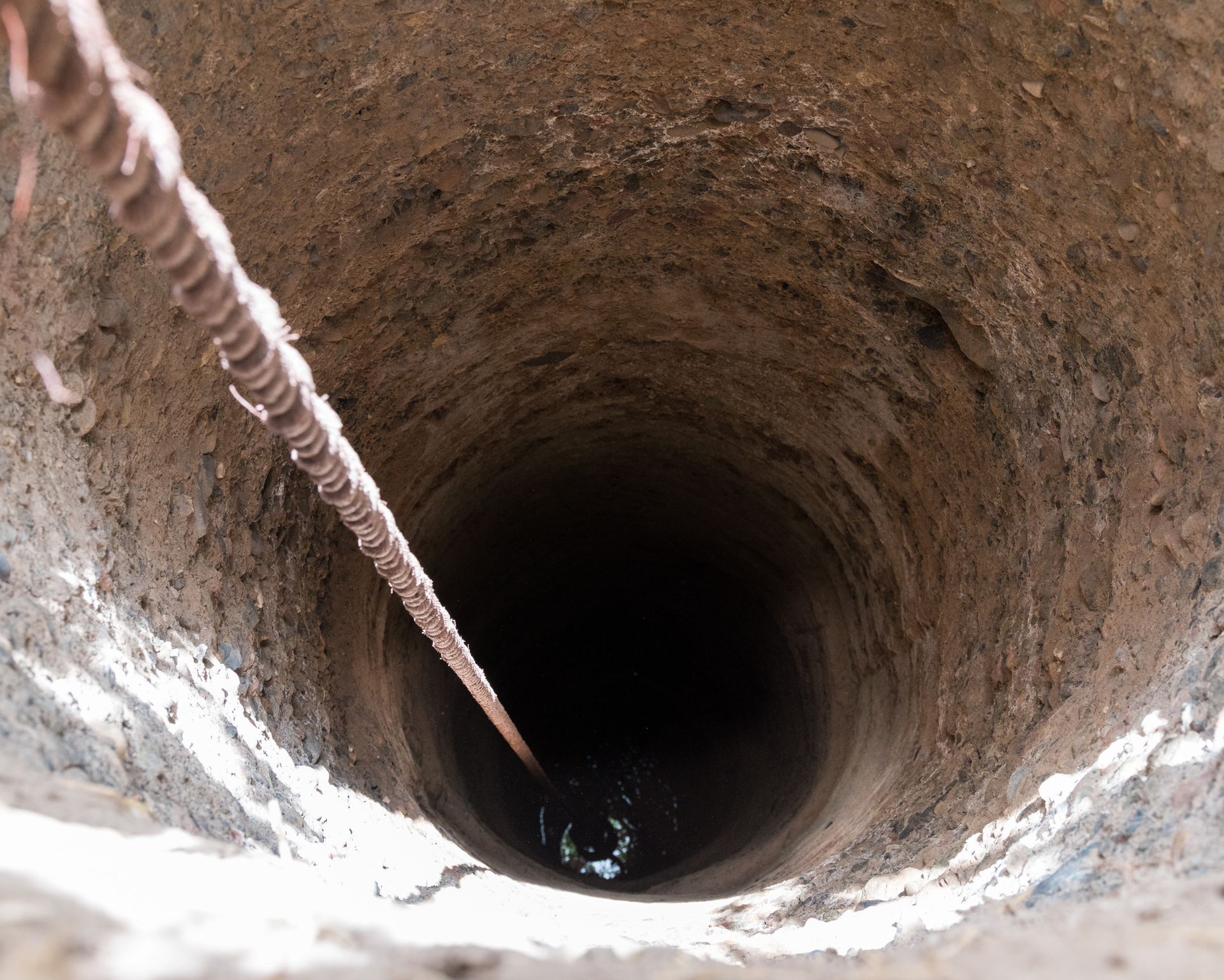 A rope is hanging from a hole in the ground