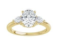 Gold ring with a large oval center diamond and two pear-shaped side diamonds.