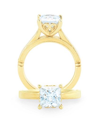 Yellow gold engagement ring with a princess-cut diamond. The band has a milgrain design.