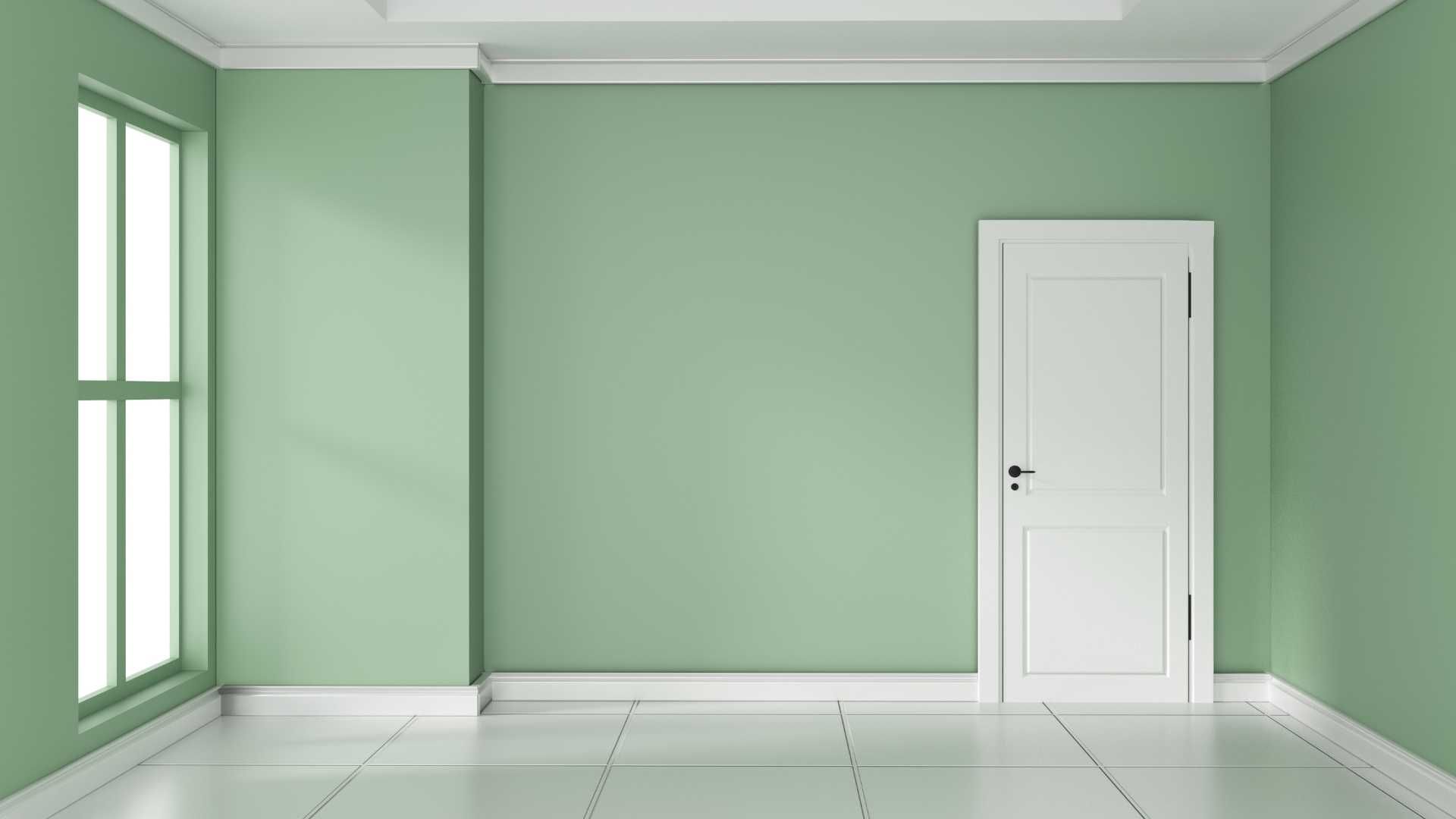 An empty room with green walls and a white door.