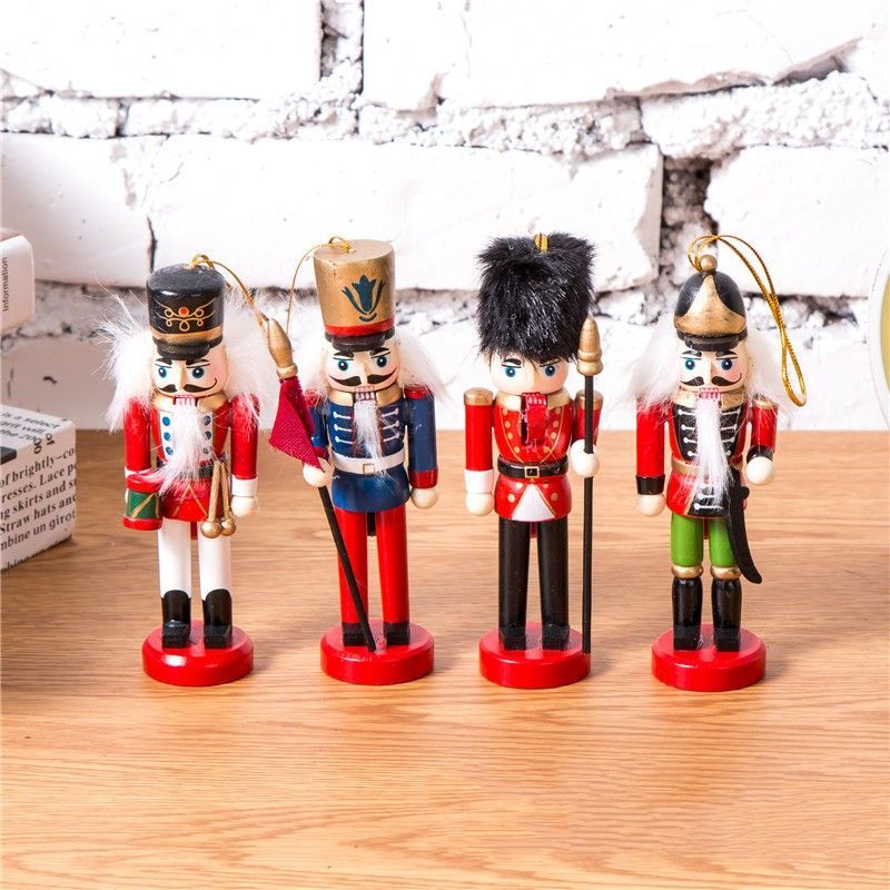 Cuatro figuras de cascanueces de madera con detalles dorados, cada una con un uniforme diferente y sosteniendo un arma.