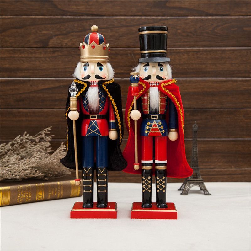 Dos figuras de cascanueces de madera, una con corona y la otra con sombrero de copa, una al lado de la otra.