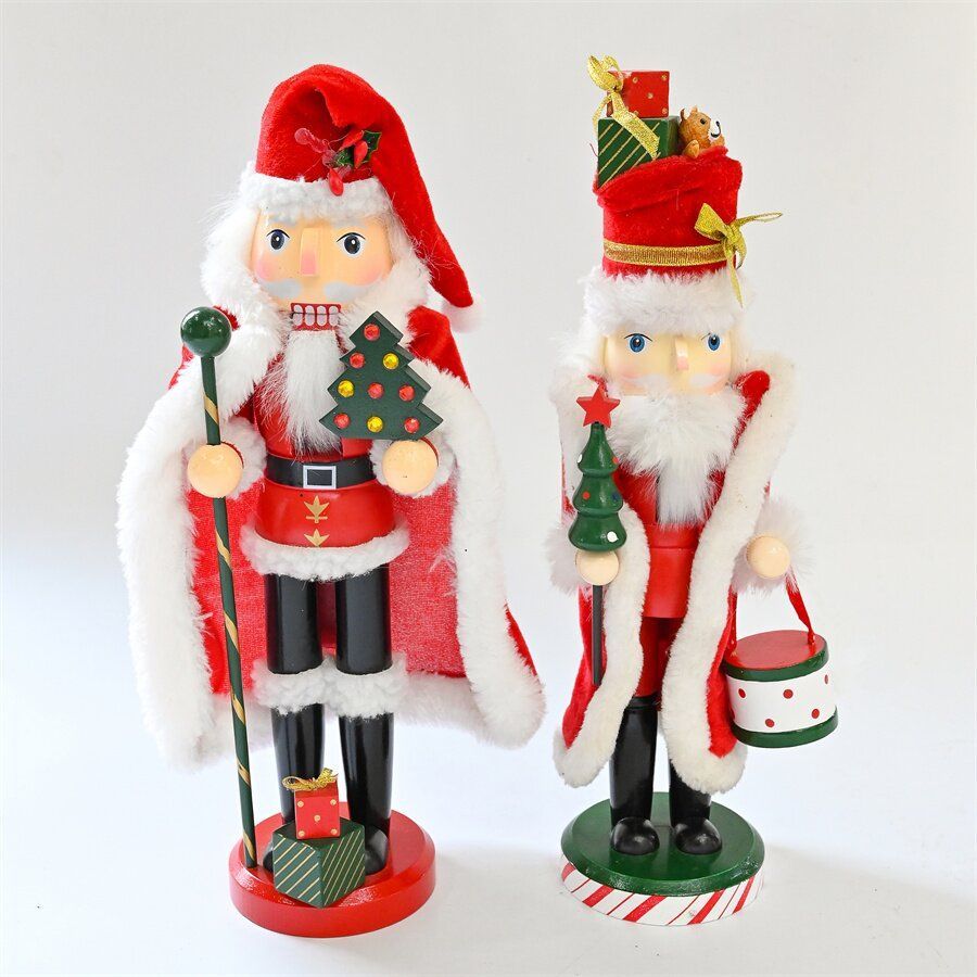 Dos cascanueces de Papá Noel con abrigos rojos, sosteniendo artículos navideños.