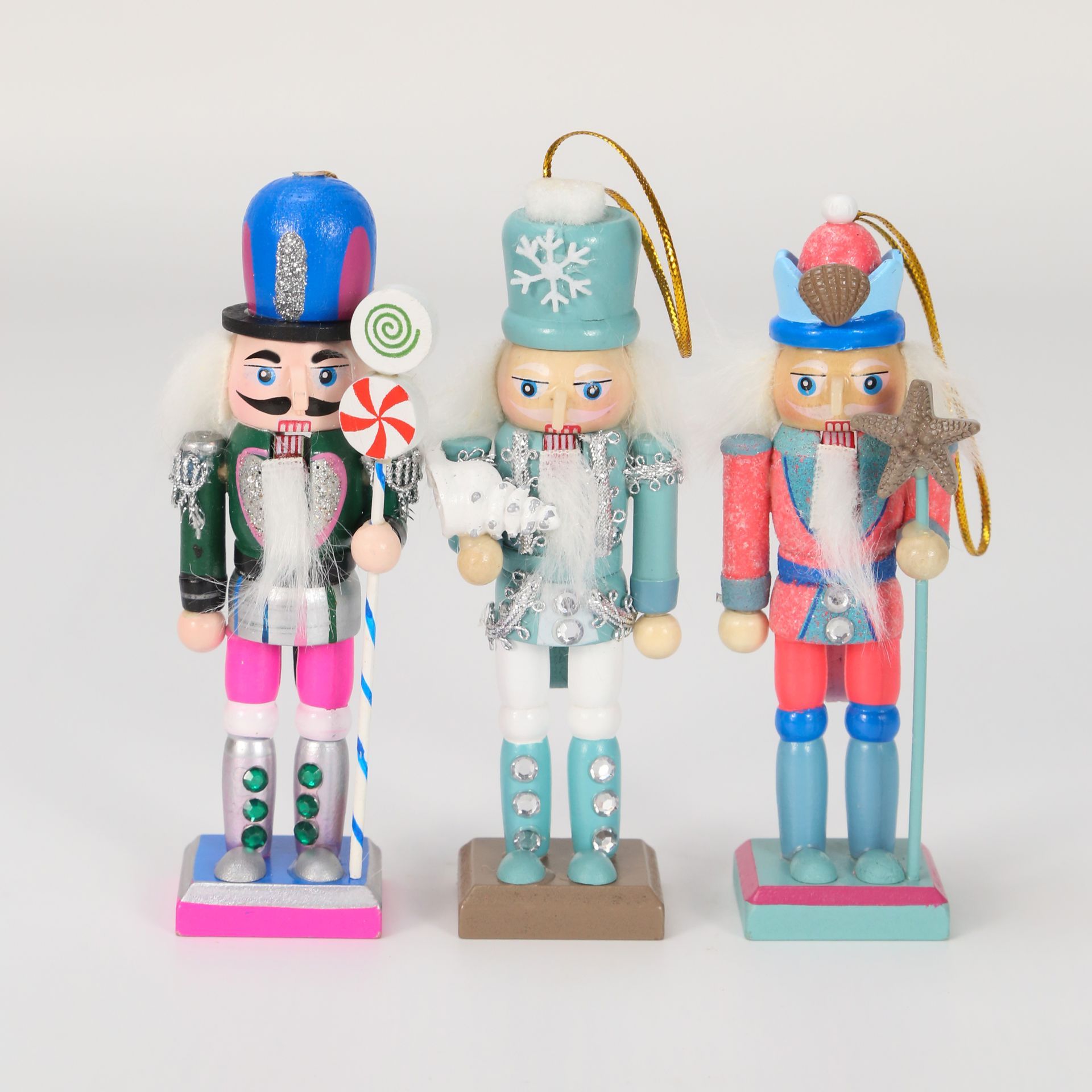 Tres coloridas figuras de cascanueces con varios sombreros y accesorios, colocadas sobre bases.