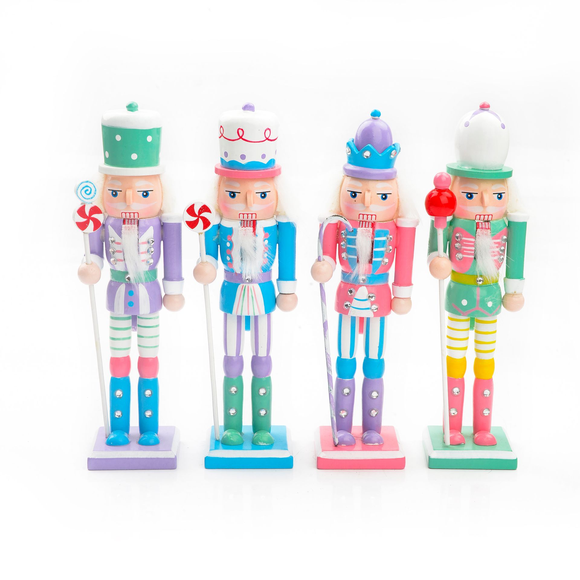 Cuatro coloridas figuras de cascanueces, una al lado de la otra. Cada una sostiene un bastón y presenta una paleta de colores única.
