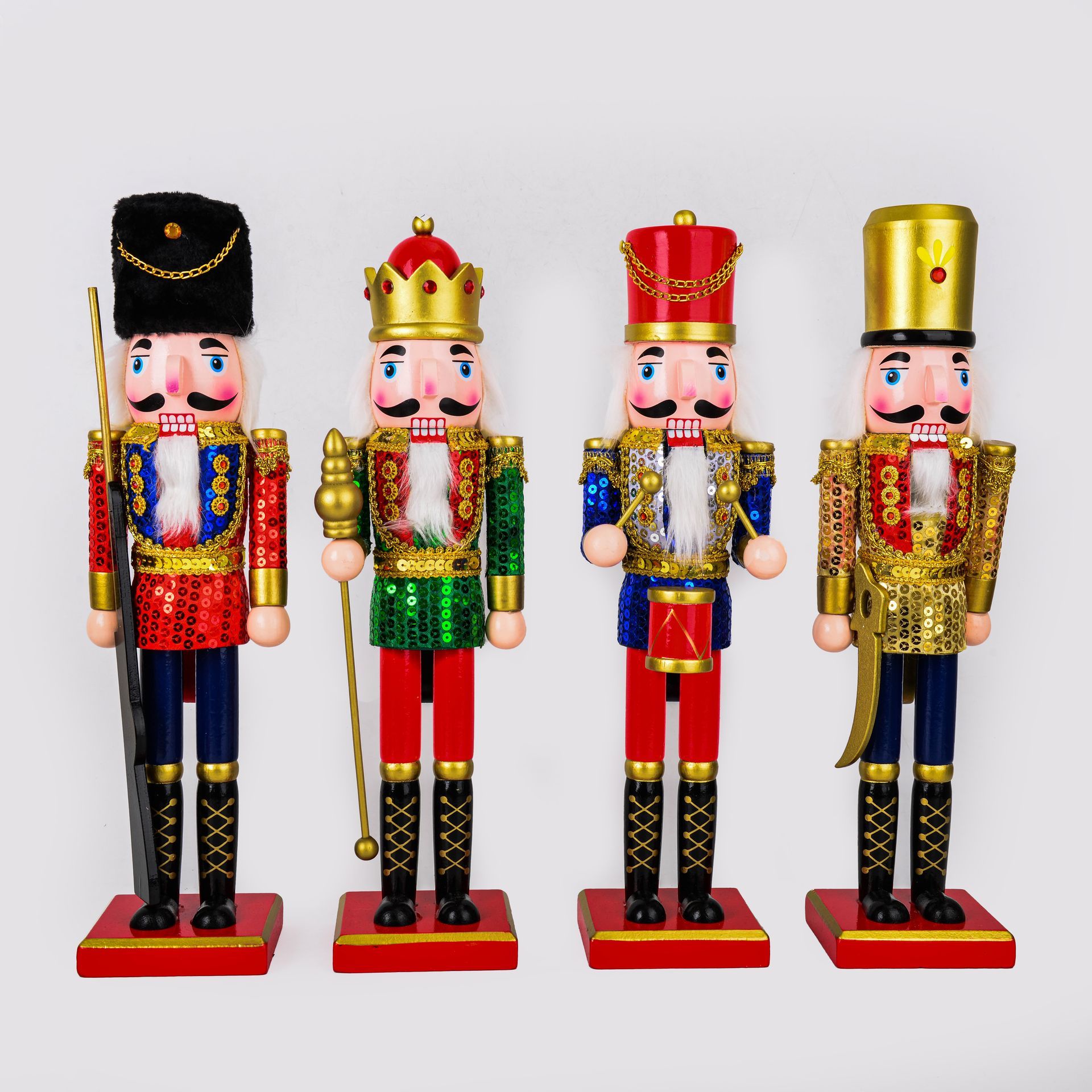 Cuatro figuras de cascanueces coloridas con diferentes uniformes, colocadas sobre bases rojas.