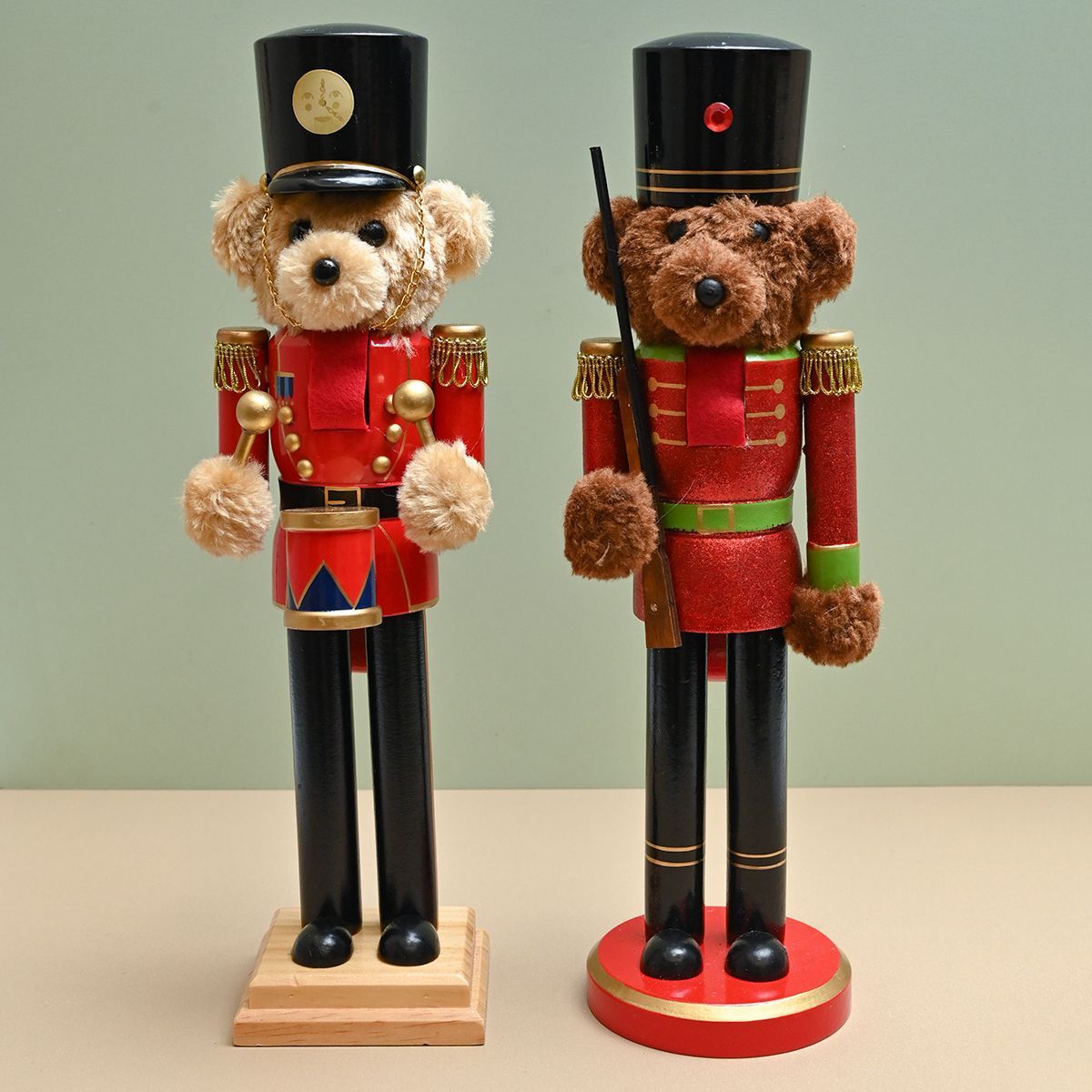 Dos cascanueces en forma de osos de peluche con uniformes rojos, sombreros negros y patas negras, parados sobre bases de madera.