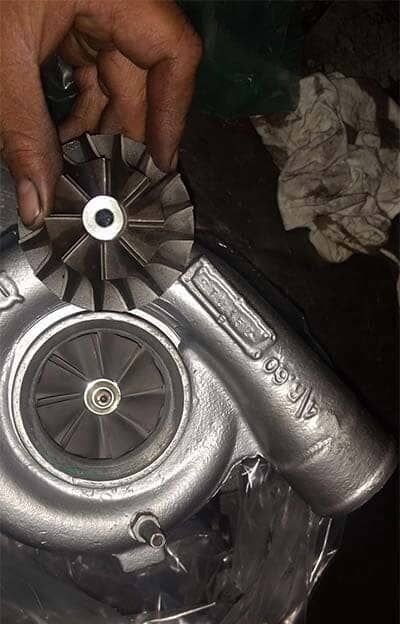 Una persona sostiene un turbocompresor en su mano.