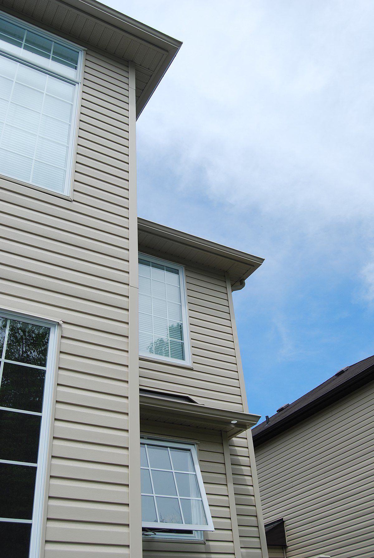 A close-up view of a house undergoing vinyl siding installation.