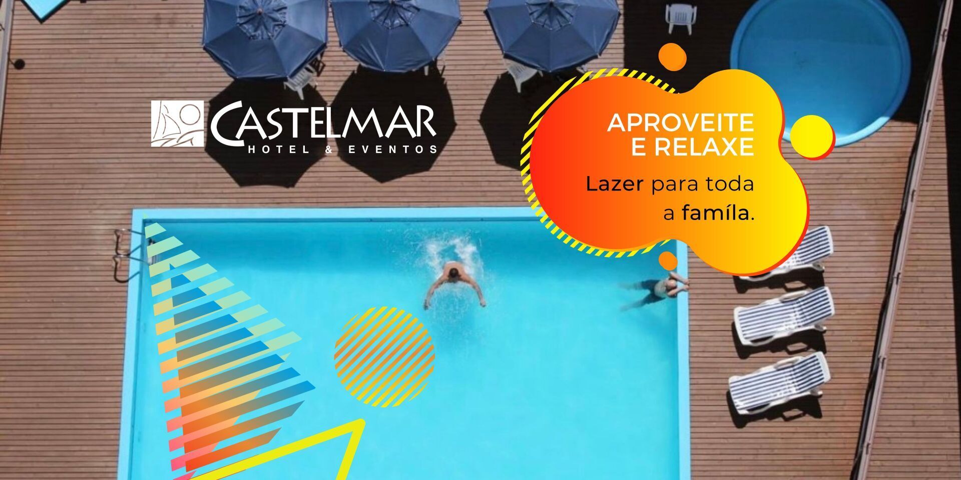 Área da piscina do hotel com nadador, guarda-sóis azuis, toalhas e um crachá promocional 