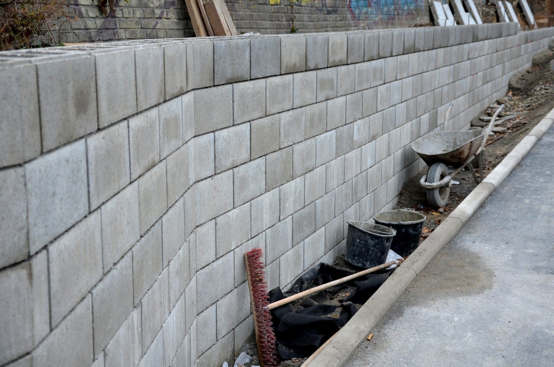 retaining wall with concrete grouting is covered with fake, optically prettier wall