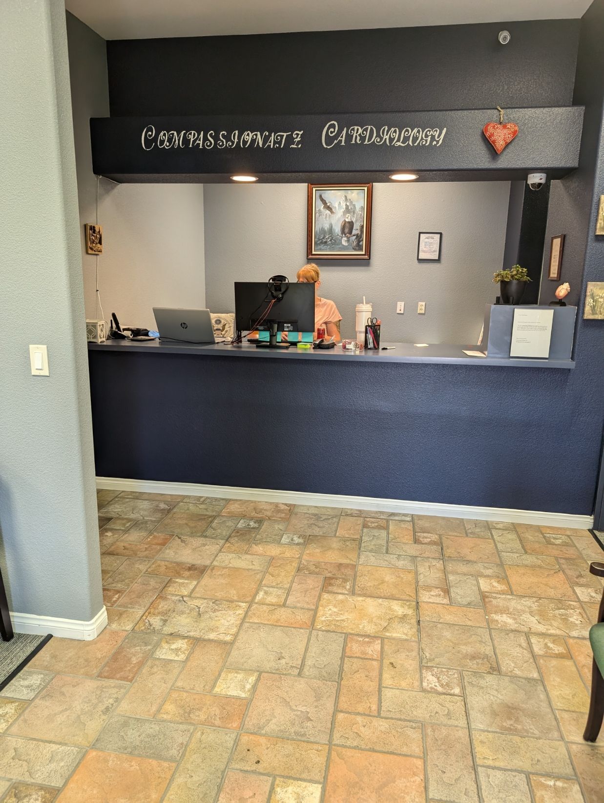 A hotel lobby with a blue counter and a tiled floor.