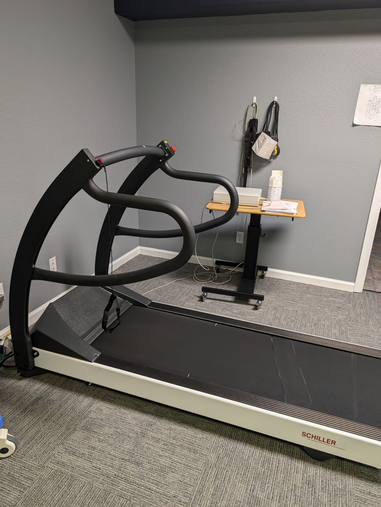 A treadmill is sitting in a room next to a table.