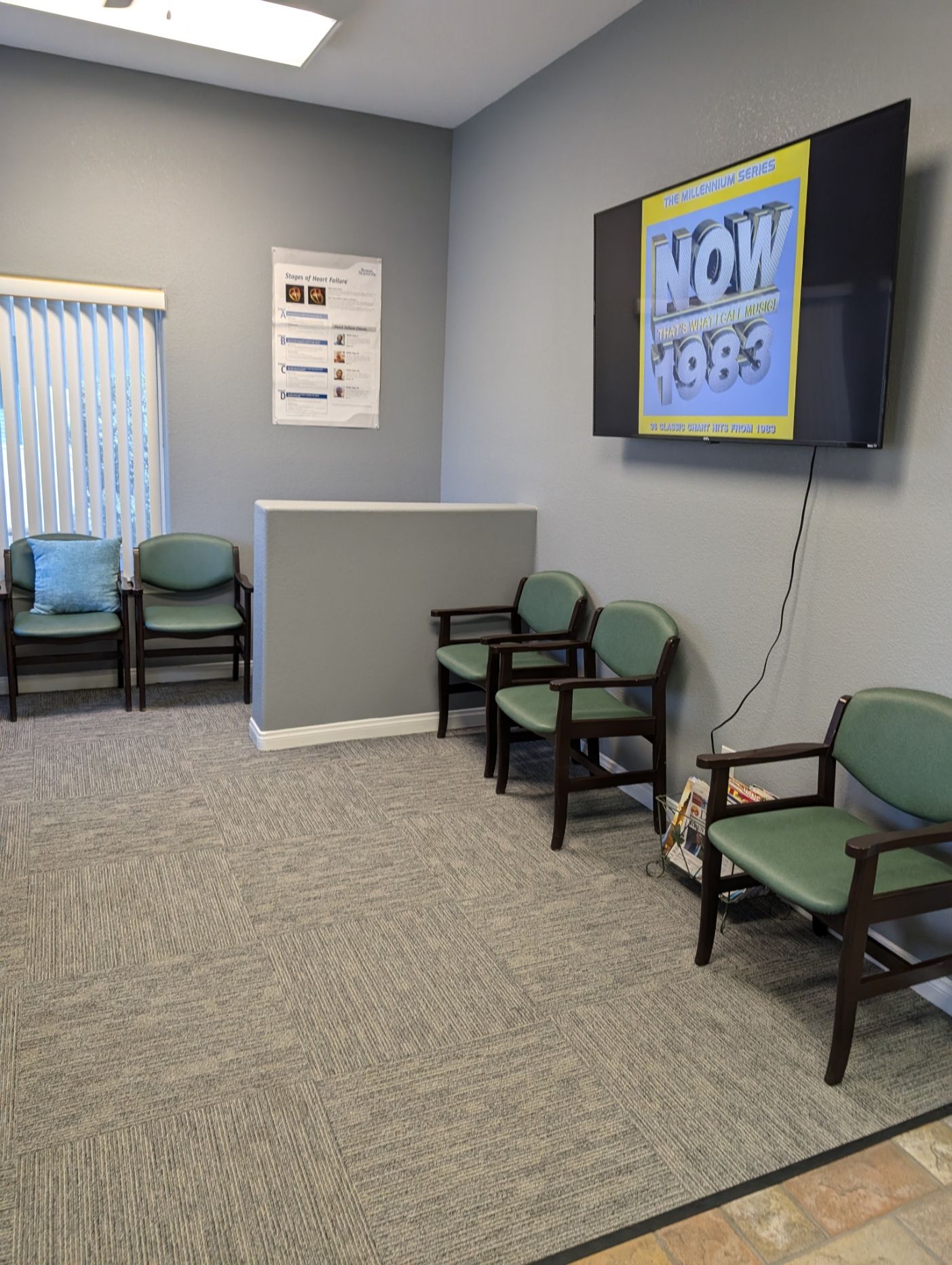 A waiting room with chairs and a television on the wall.