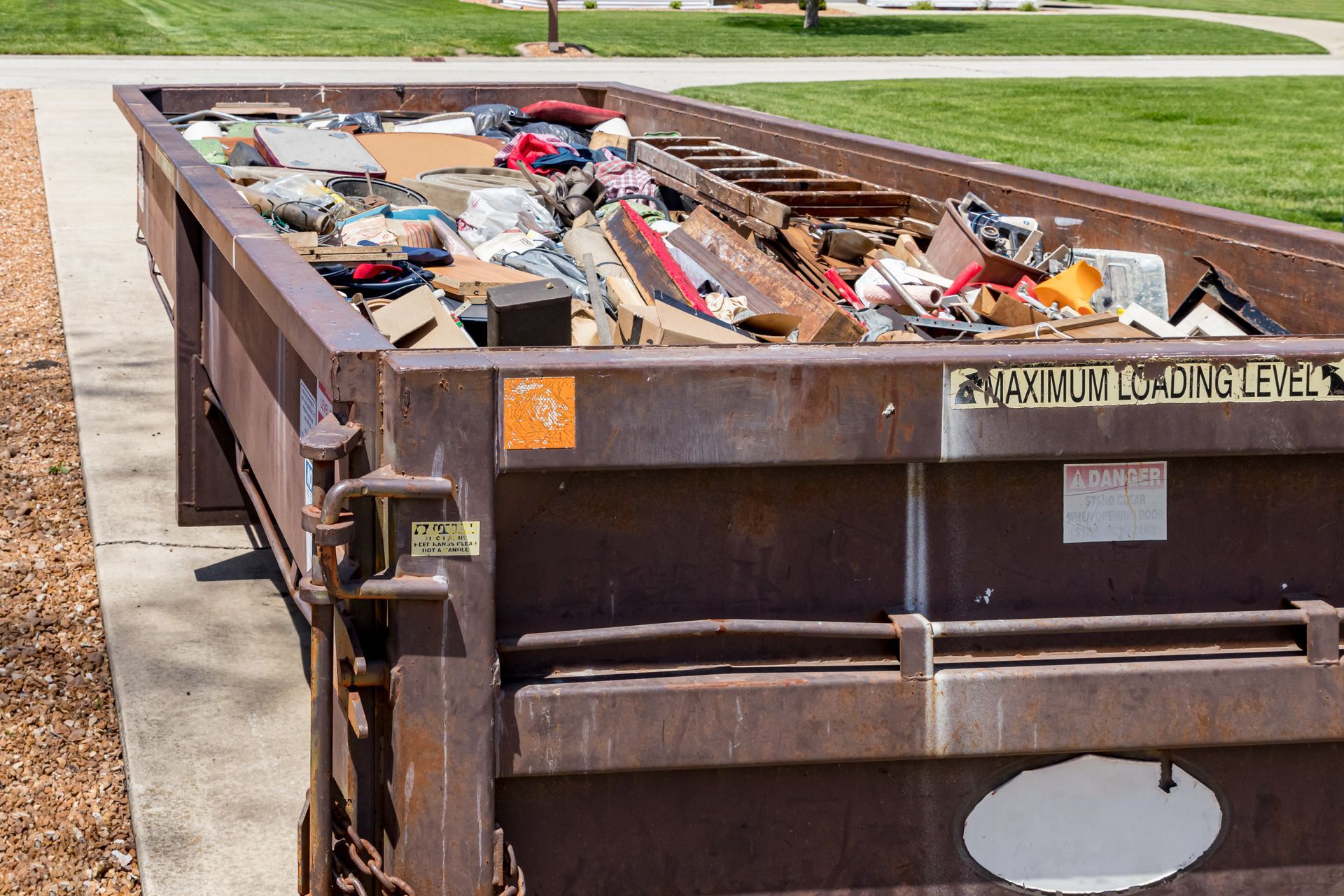Large roll-off dumpster filled with construction debris and household junk.
