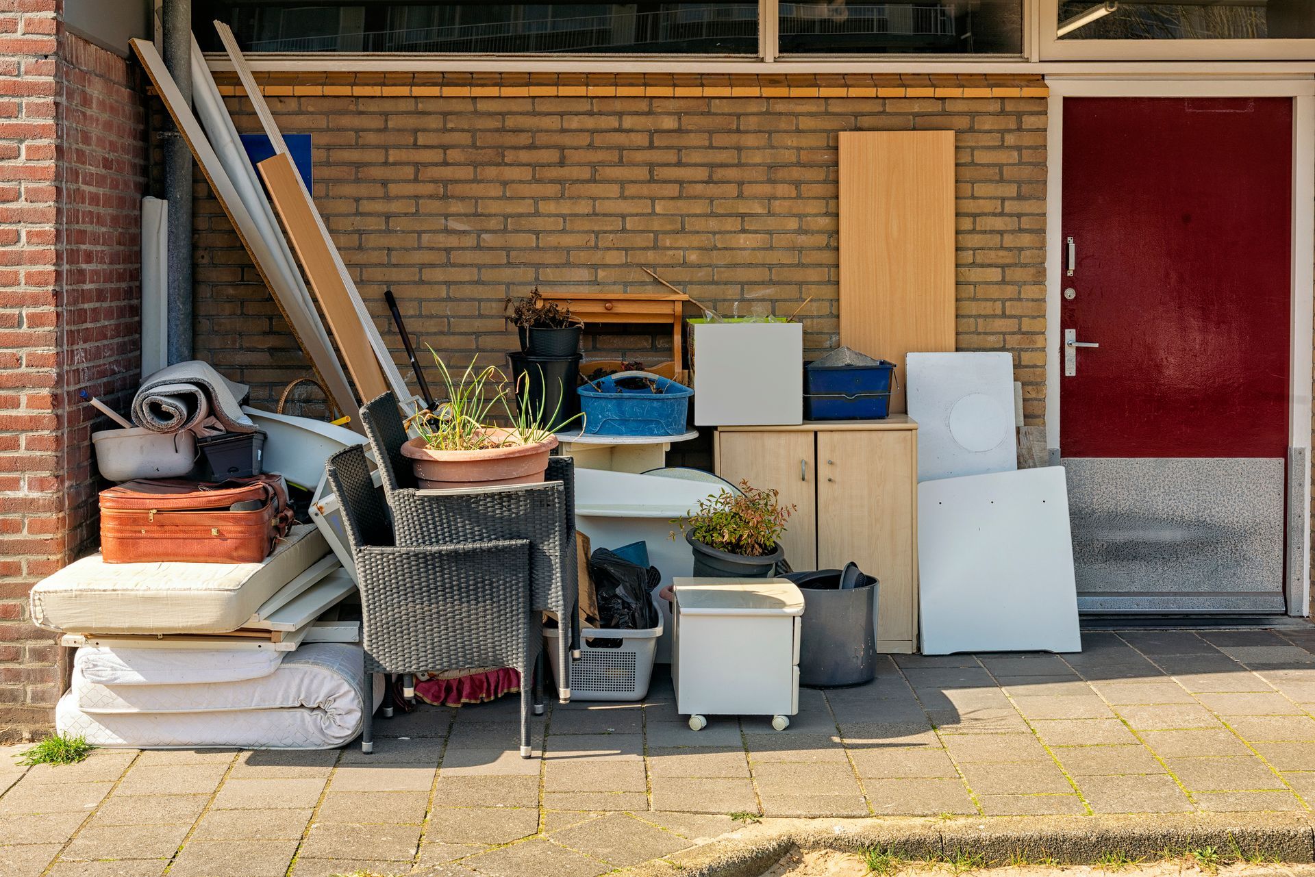 Household waste is dumped outside in a corner of an apartment building.