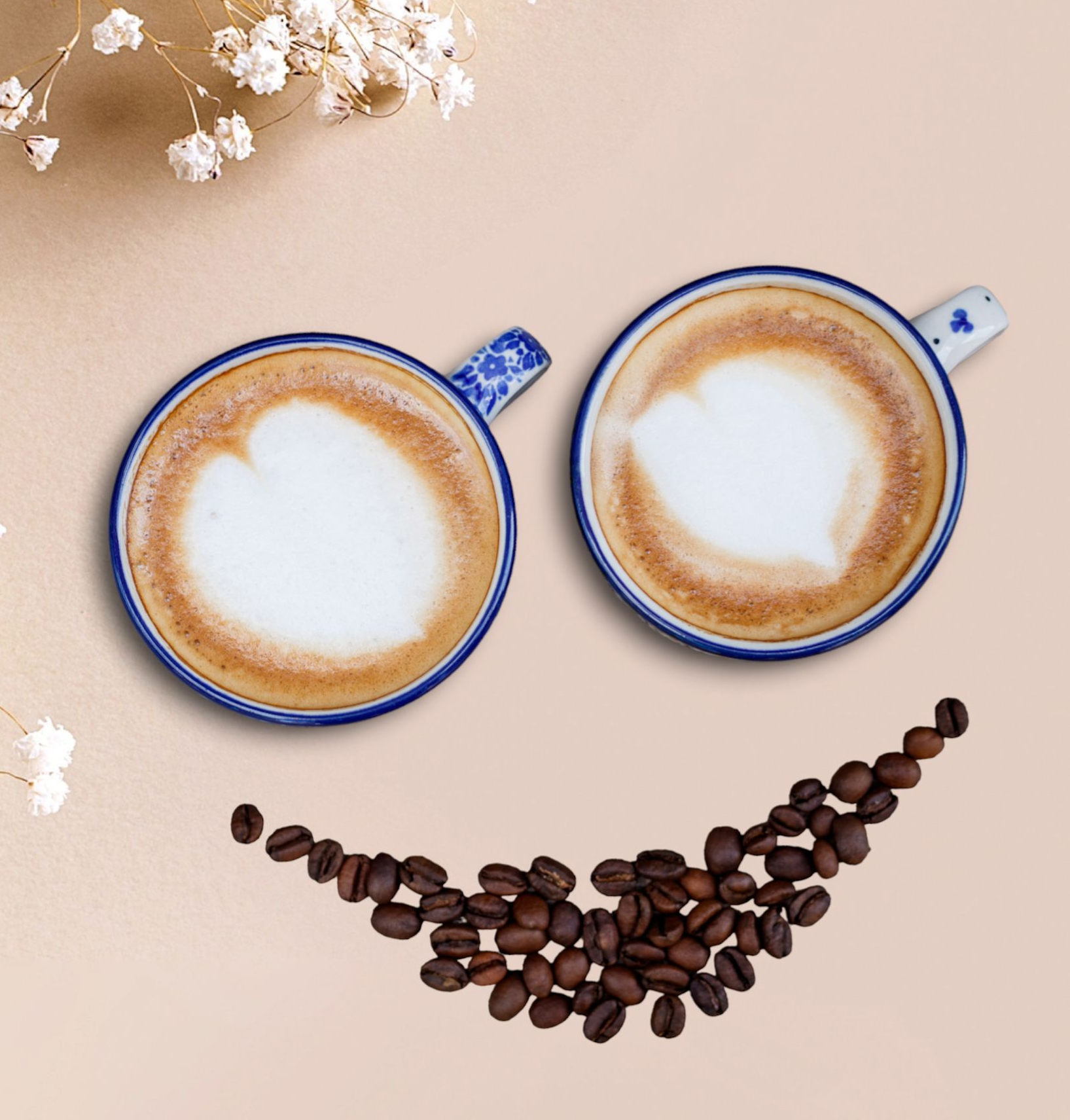 Twee koffiekopjes met latte art en een glimlach gemaakt van koffiebonen.
