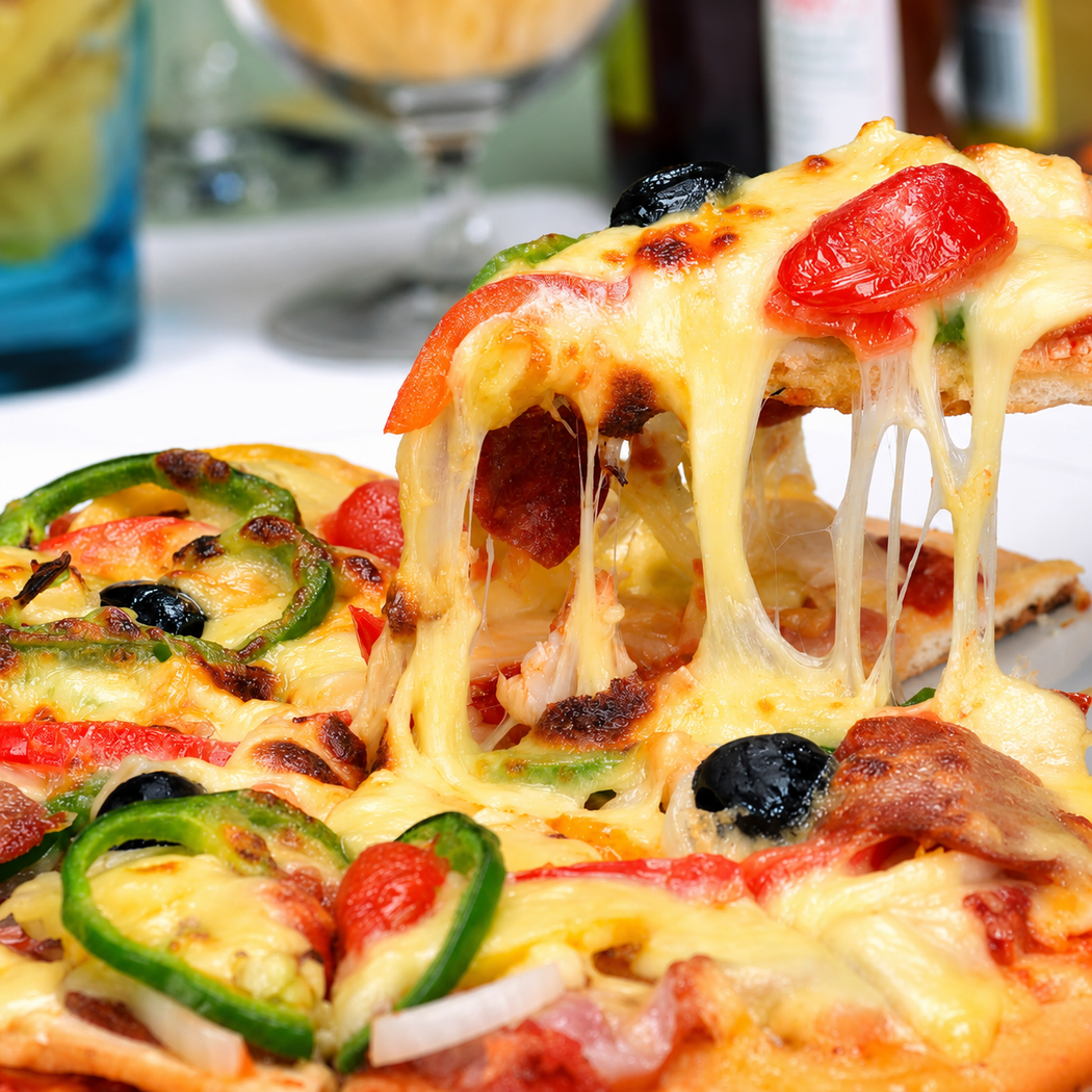 Una fetta di pizza al formaggio viene sollevata, con formaggio fuso, peperoni, olive e funghi su un piatto.