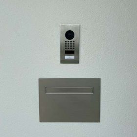 There is a mailbox and a doorbell on the wall.