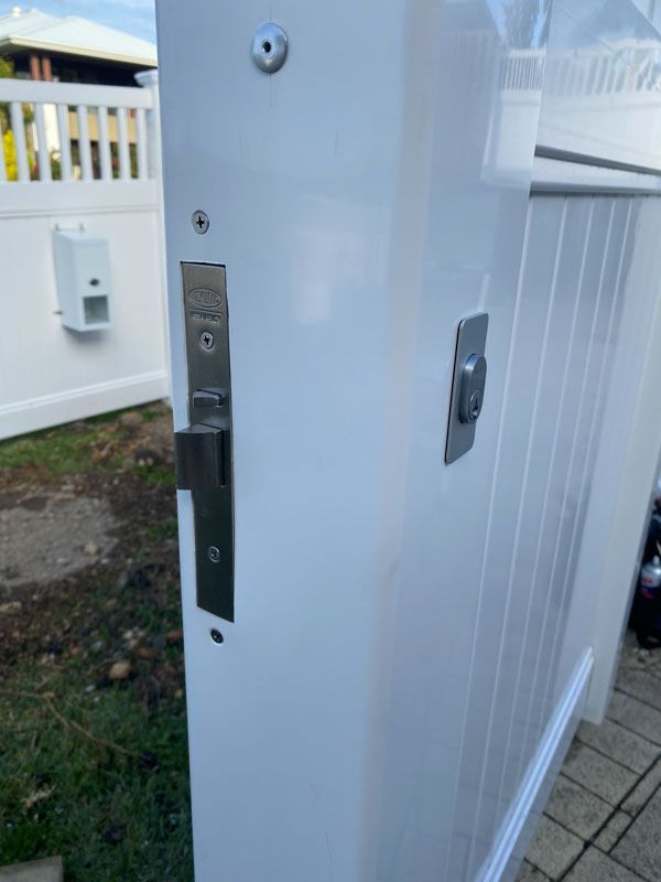 A close up of a white door with a lock on it.