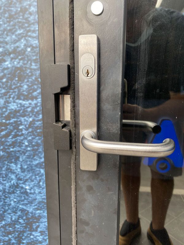 A person is standing in front of a door with a lock on it.