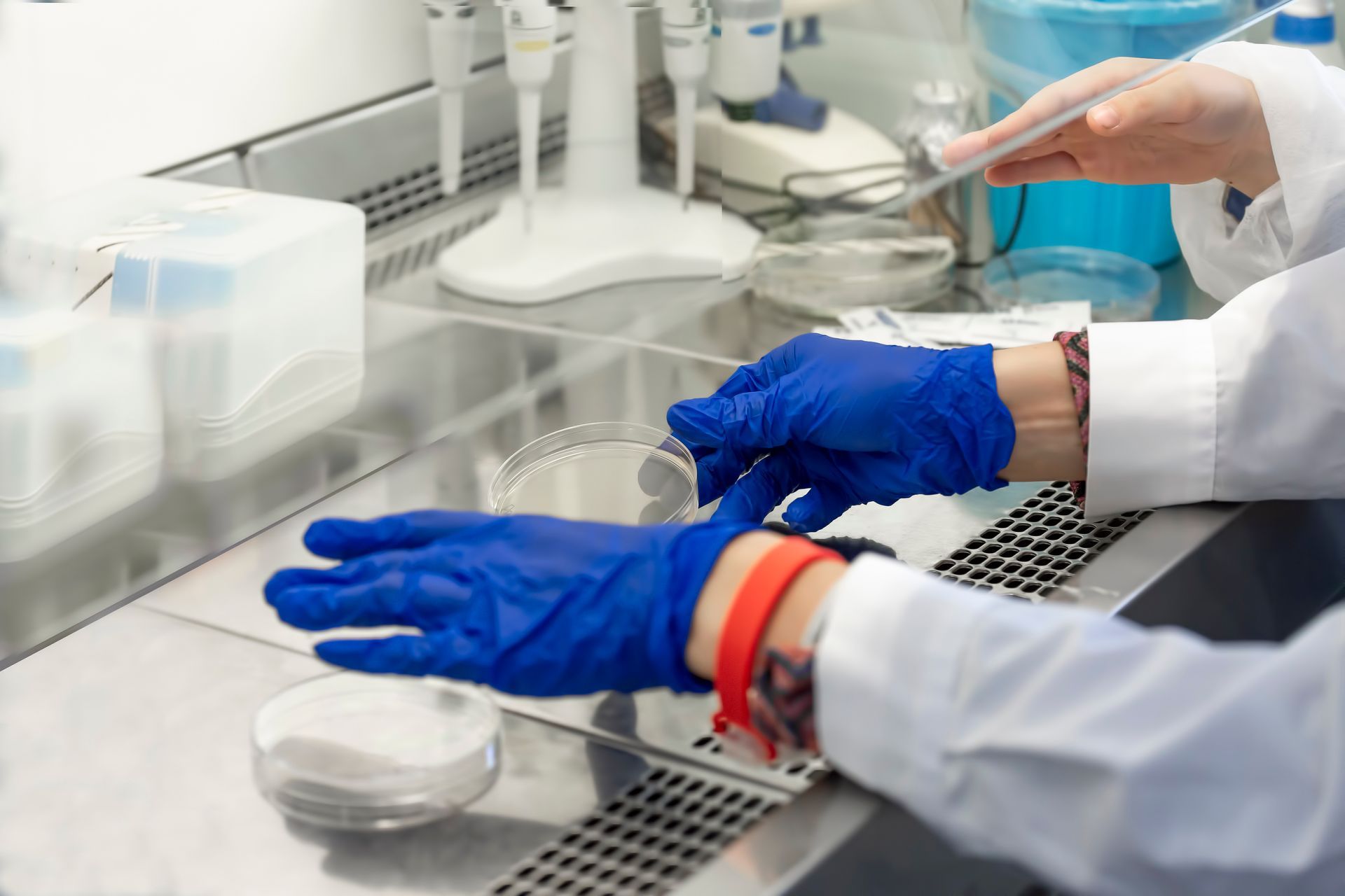 Une personne portant des gants bleus travaille dans un laboratoire.