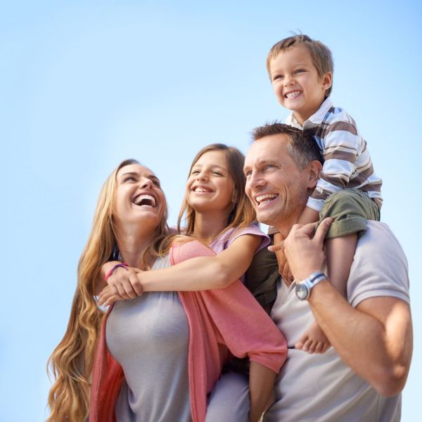 A man is carrying two children on his shoulders