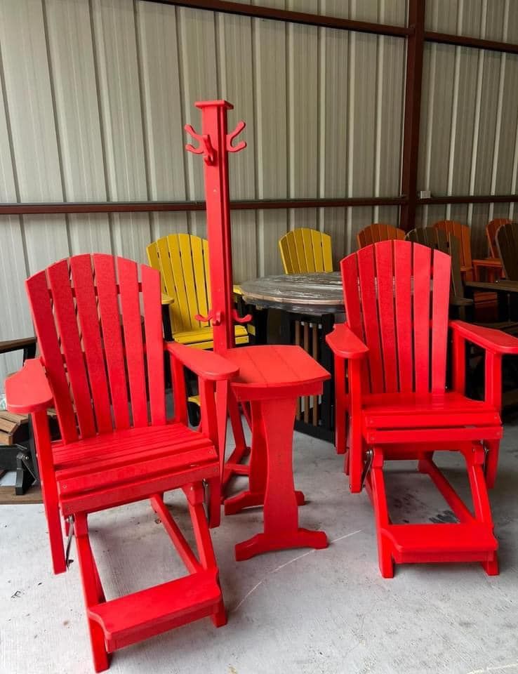 A set of red adirondack chairs and a table
