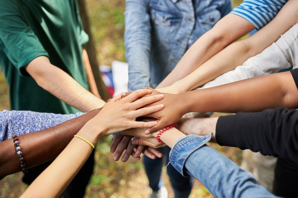 Group With Hands Together In Support — Humanitarian Support in Forster, NSW