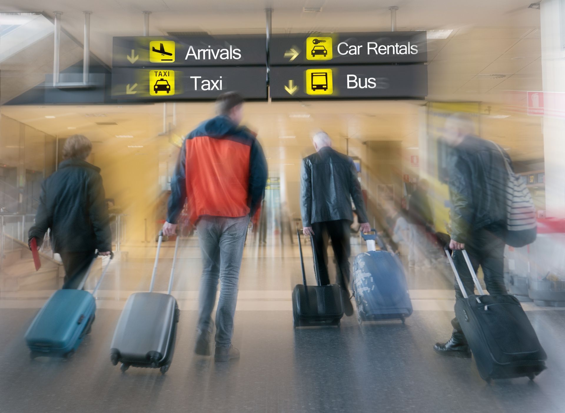 airport travelers under a sign that reads arrivals car rentals taxi and bus