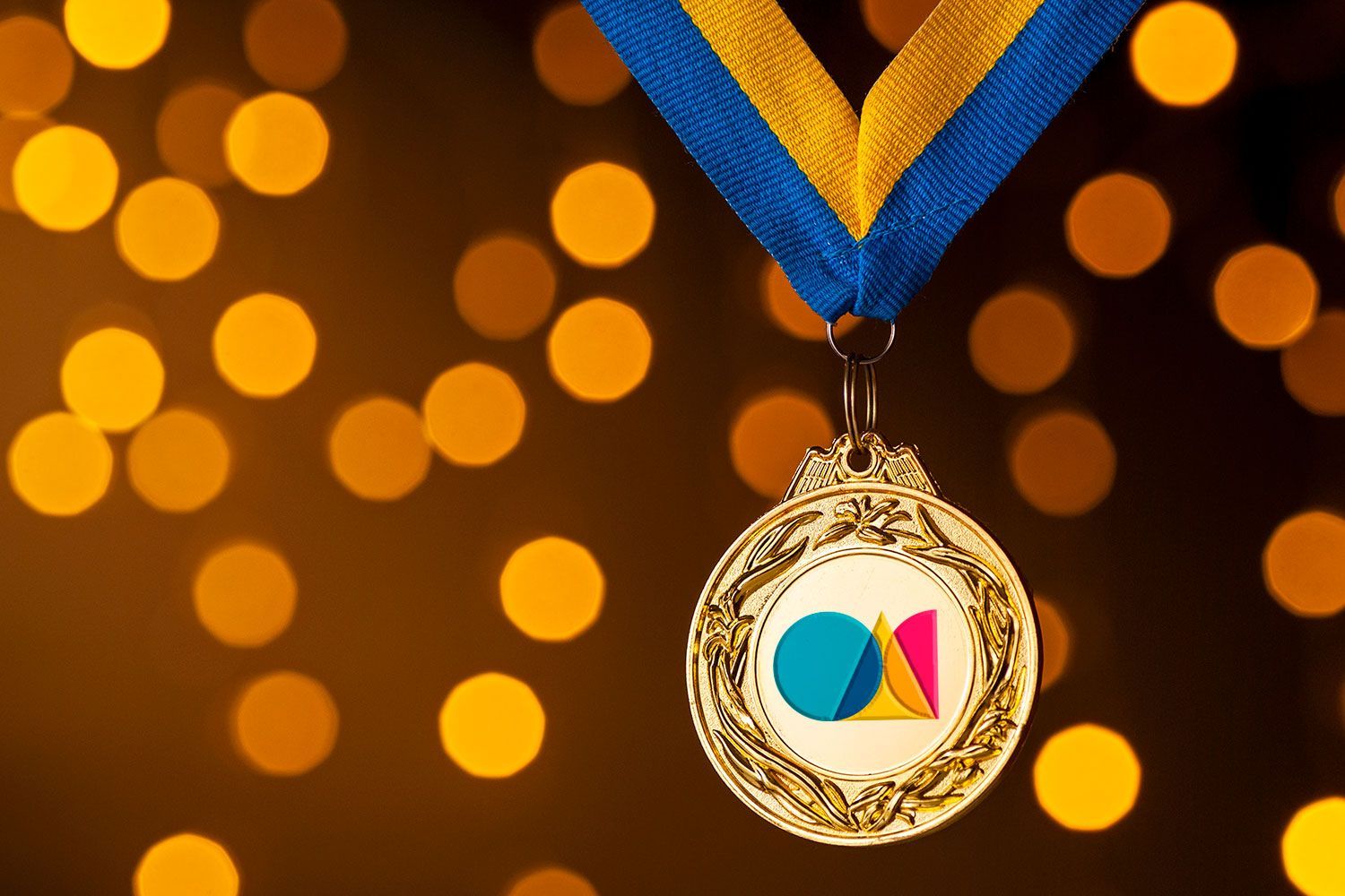 A gold medal with a blue and yellow ribbon around it