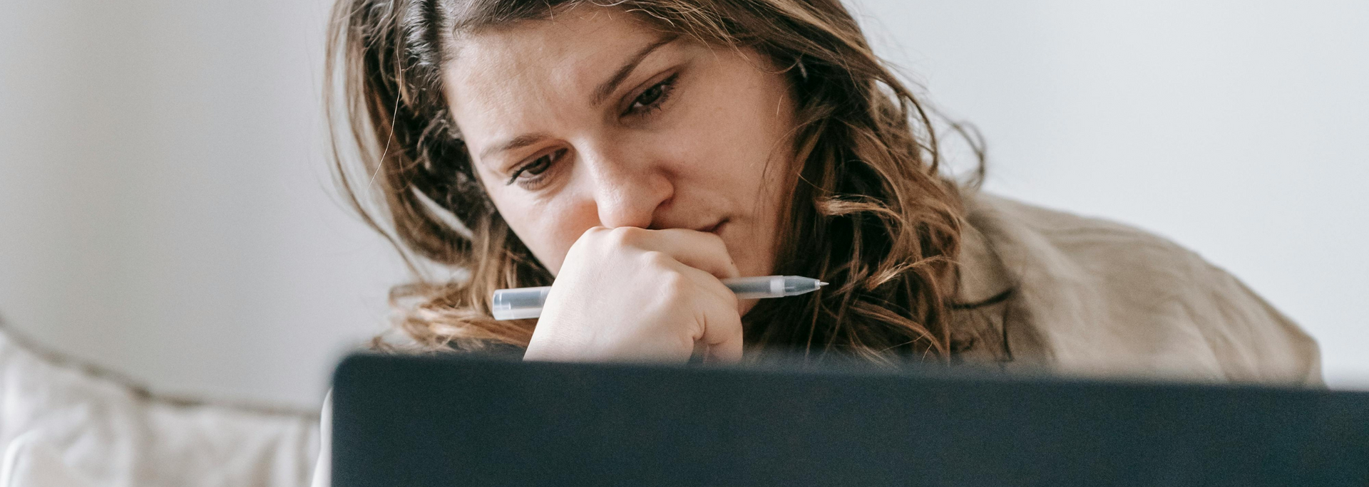 Picture of someone looking thoughtful at a computer.