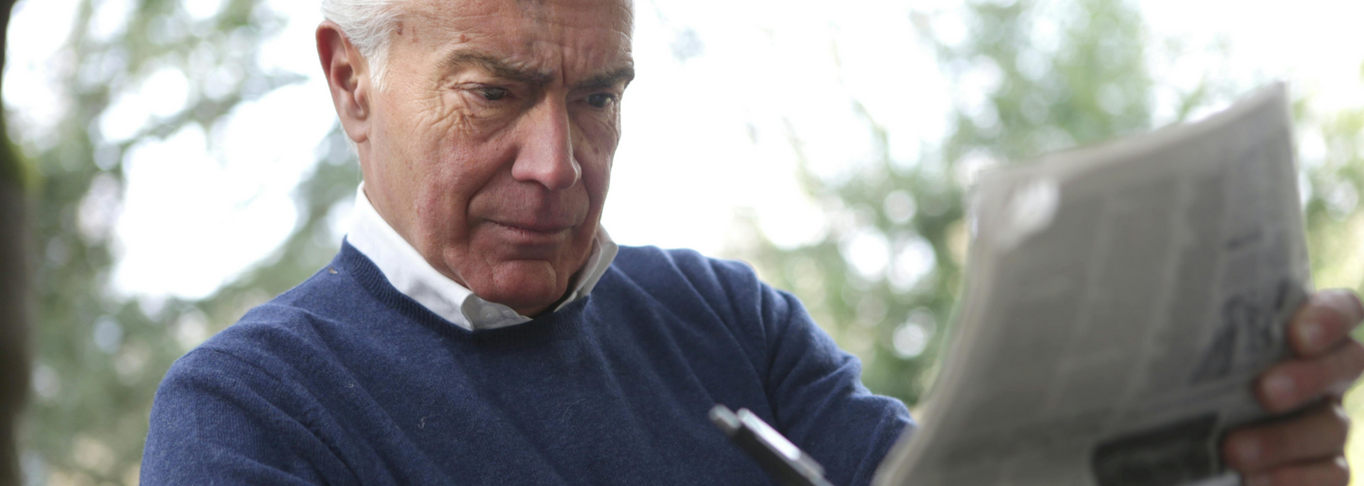 Picture of someone looking through a newspaper.