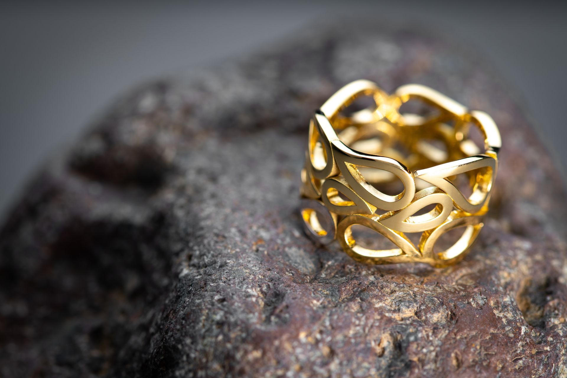A gold ring is sitting on top of a rock.