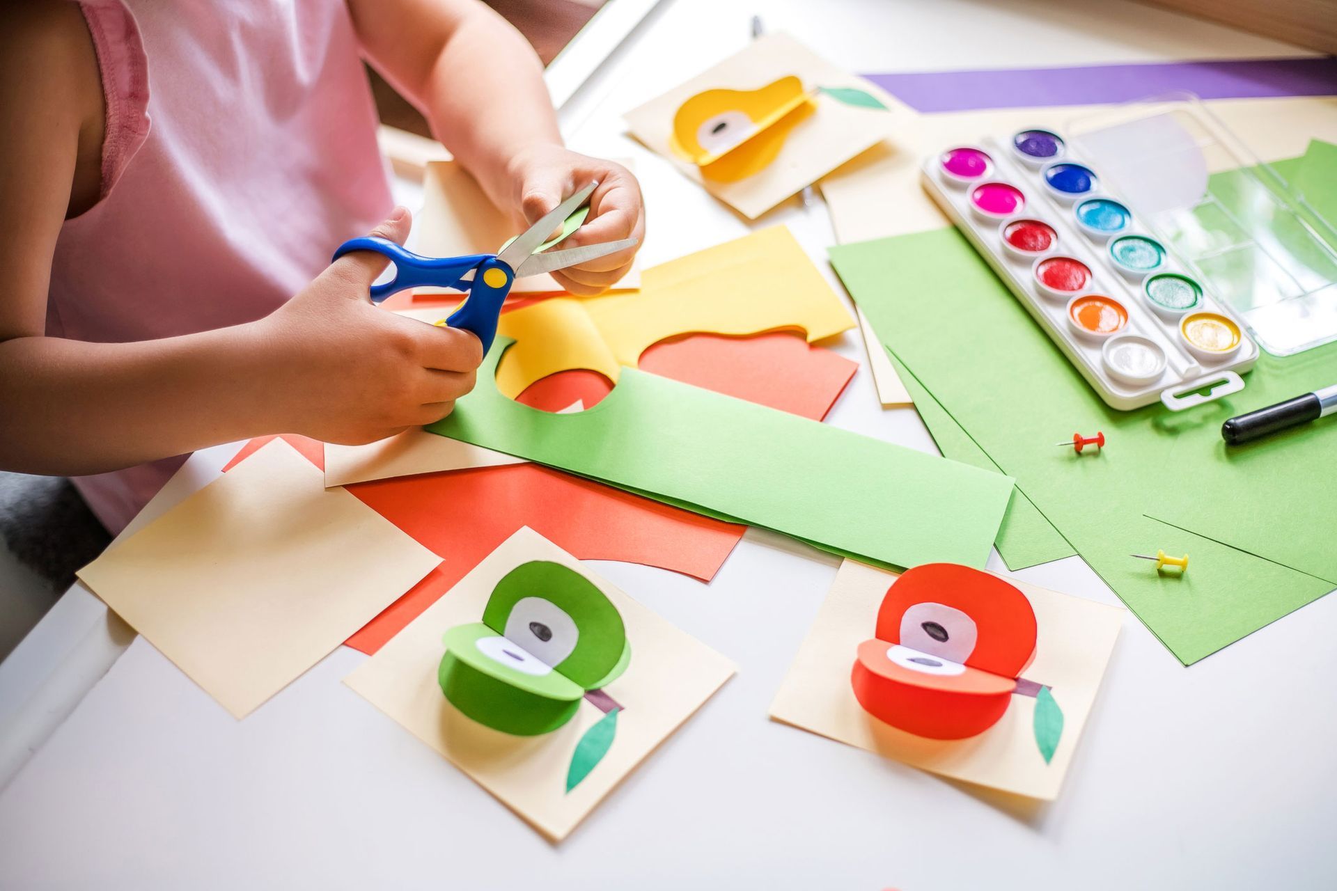 Little Girl Cutting Colorful Paper at The Table — Kempsey, NSW — Kempsey Family Day Care