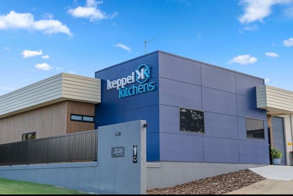 Modern blue-and-gray building with “Kepel Kitchens” sign under a bright sky — Keppel Kitchens in Yeppoon, QLD