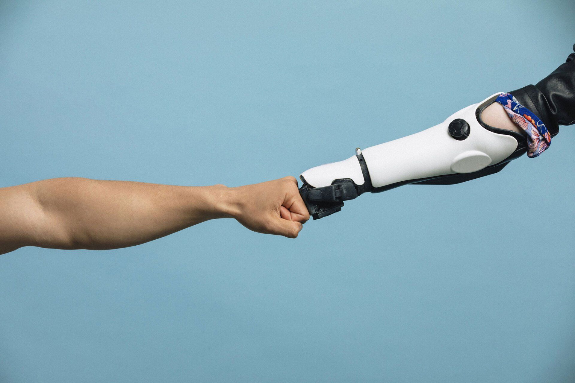 Human Hand and Robotic Hand Making a Fist Bump — Pembroke Pines, FL — Huse Artificial Limb & Brace