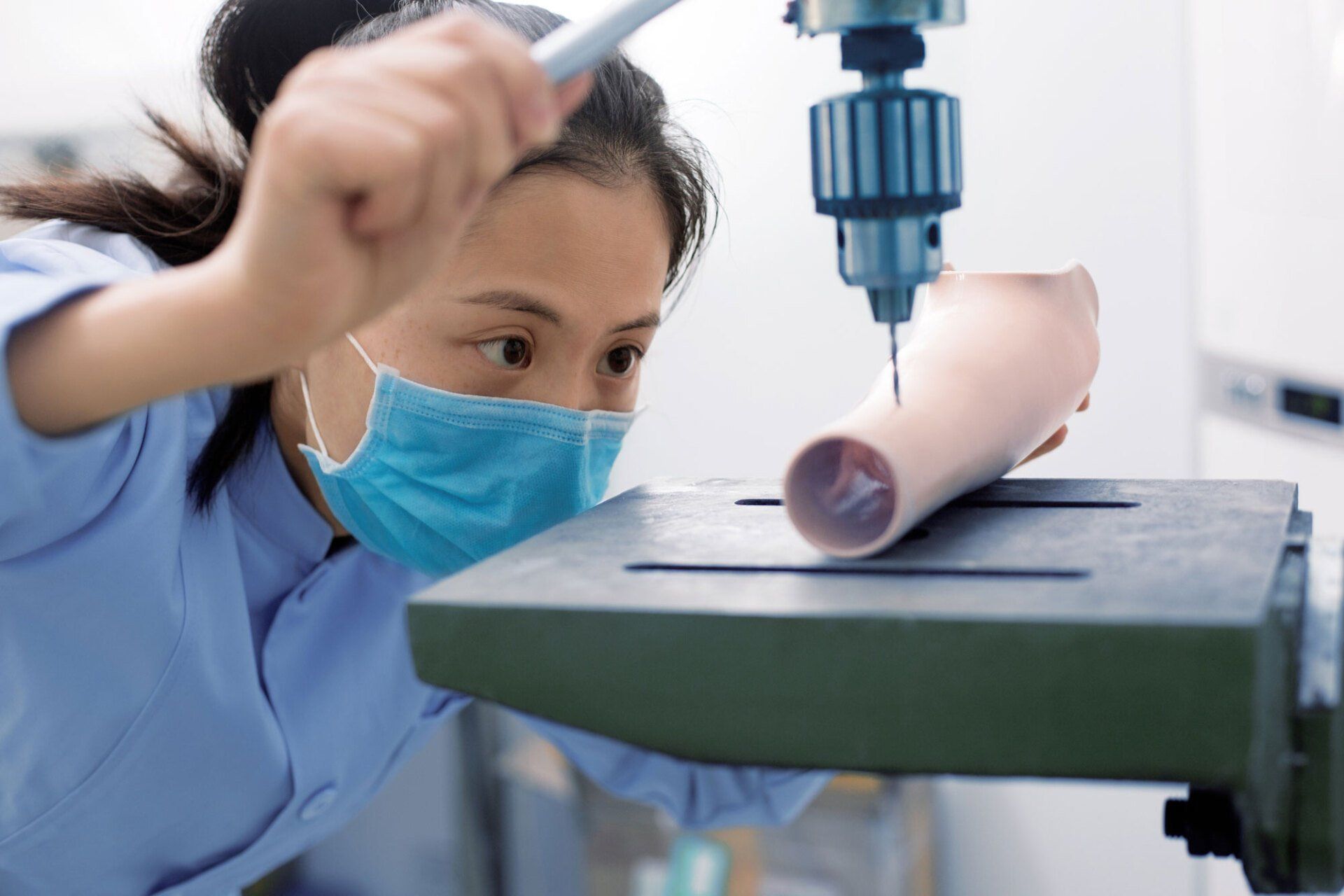 Worker Using a Drilling Machine to Process a Prosthetic — Pembroke Pines, FL — Huse Artificial Limb & Brace Worker Using a Drilling Machine to Process a Prosthetic — Pembroke Pines, FL — Huse Artificial Limb & Brace