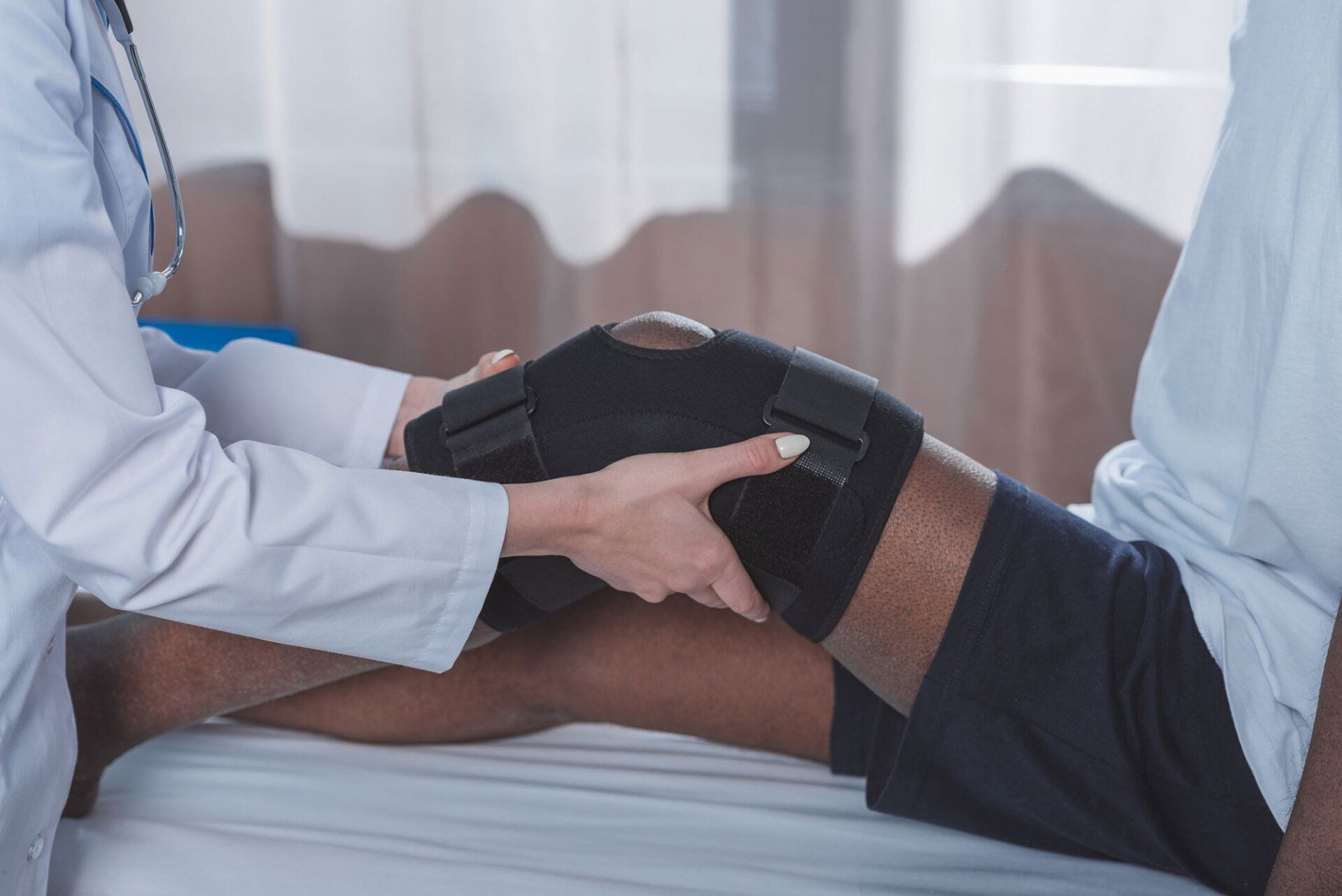 Doctor Putting on Knee Brace — Pembroke Pines, FL — Huse Artificial Limb & Brace