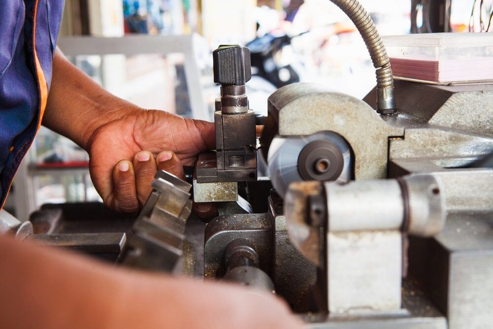A Man Is Using a Machine to Make a Key — East Coast Locksmiths in Port Macquarie, NSW