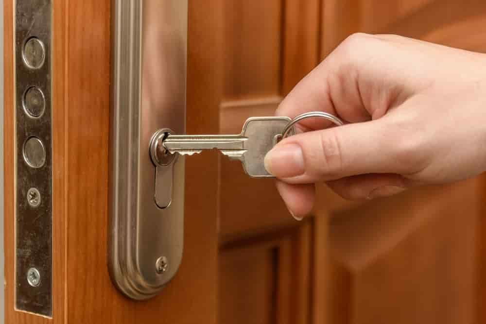 A Person Is Opening a Door with A Key — East Coast Locksmiths in Kew, NSW