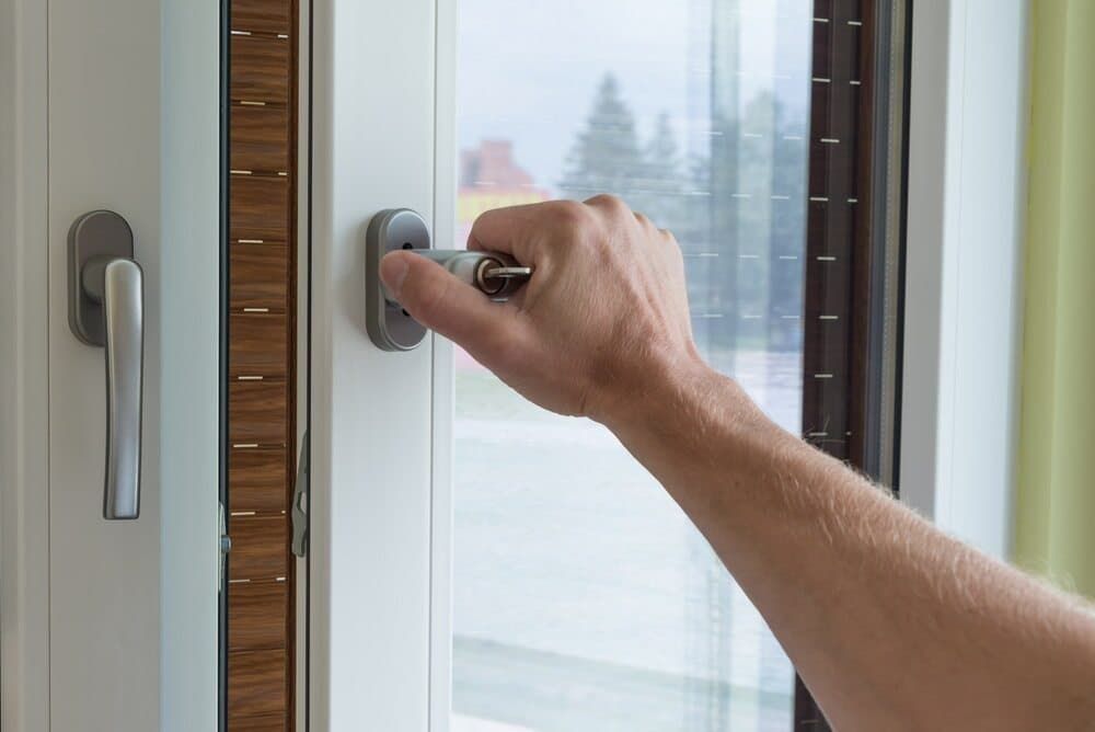 A Person Is Opening a Window with Their Hand — East Coast Locksmiths in Laurieton, NSW