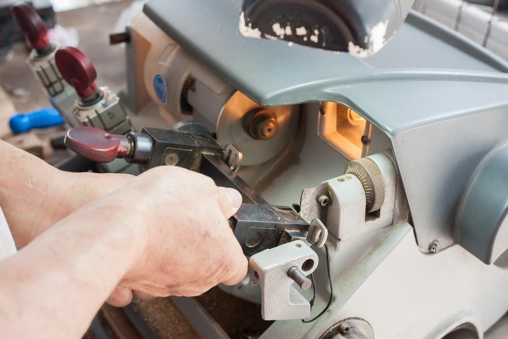 A Person Is Using a Machine to Make a Key — East Coast Locksmiths in Kew, NSW