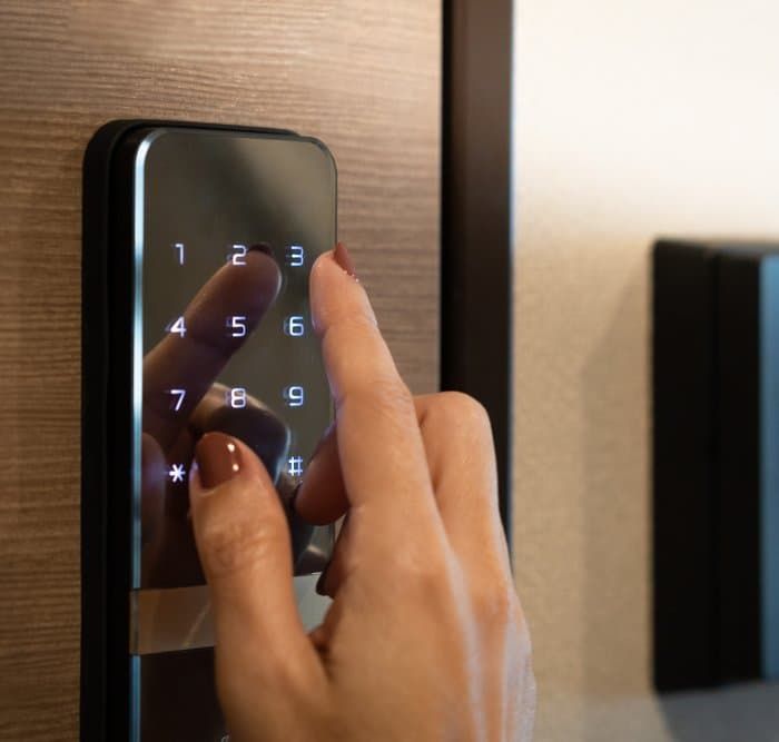 A Person Is Pressing a Button on A Door Lock — East Coast Locksmiths in Kempsey, NSW