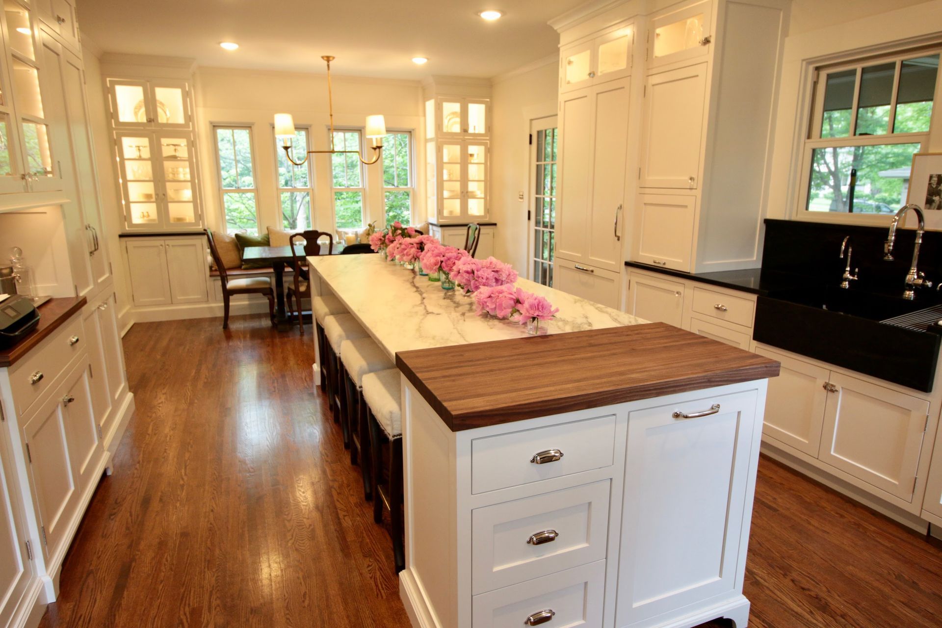 A custom kitchen with a long island and a table with pink flowers on it. Custom cabinets Columbia Missouri 