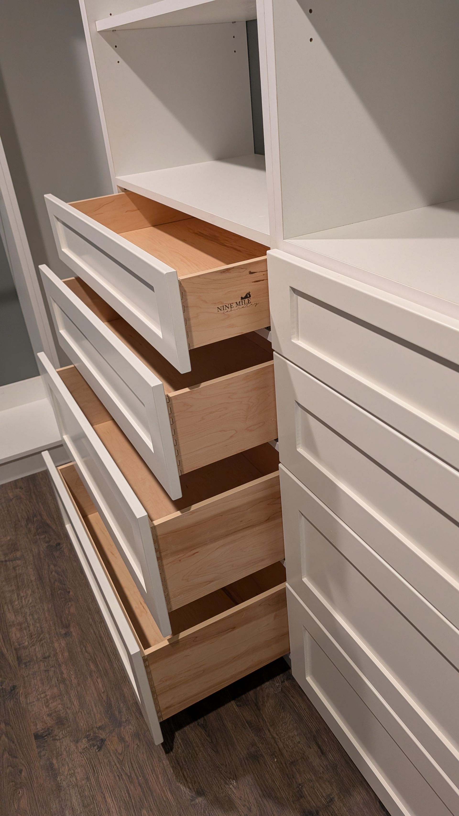 A custom closet with white drawers and wooden drawers in Columbia MO