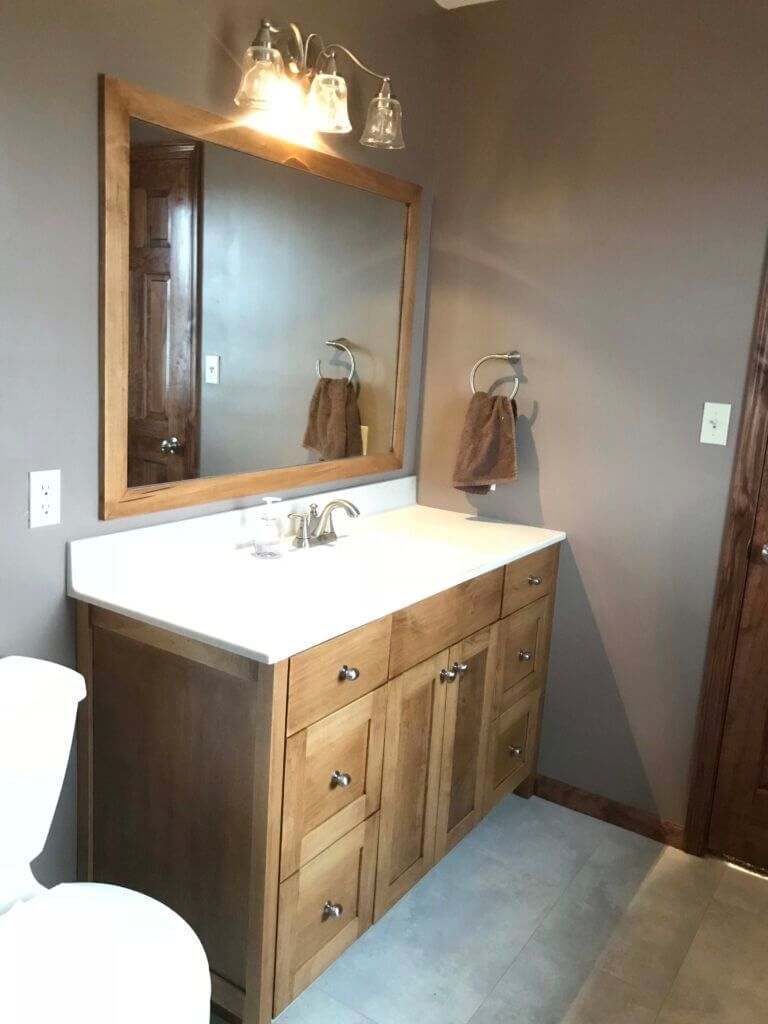 A bathroom with a sink , toilet and mirror. Custom cabinets Columbia Missouri 