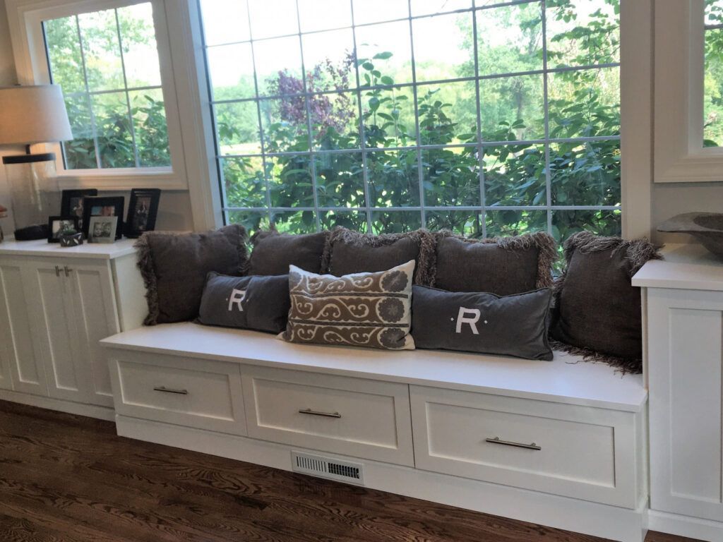 A living room with a window seat filled with pillows and drawers in Mid-Missouri.